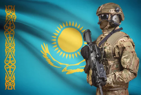 Soldier in helmet holding machine gun with flag on background series - Kazakhstan — Stock Photo, Image