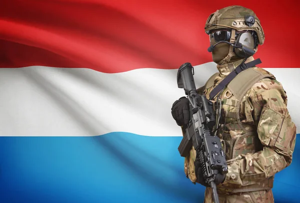 Soldier in helmet holding machine gun with flag on background series - Luxembourg — Stock Photo, Image