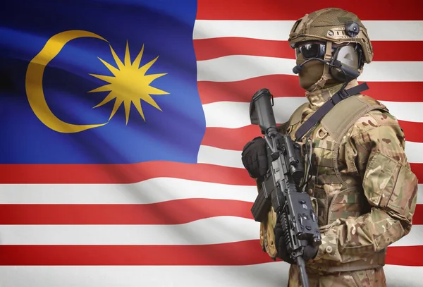 Soldier in helmet holding machine gun with flag on background series - Malaysia — Stok Foto