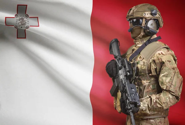 Soldier in helmet holding machine gun with flag on background series - Malta — Stok Foto