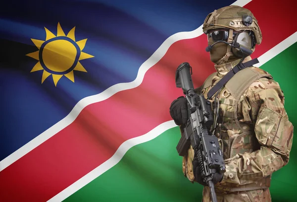 Soldier in helmet holding machine gun with flag on background series - Namibia — Stock Photo, Image