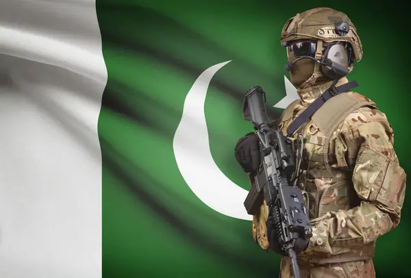 Soldier in helmet holding machine gun with flag on background series - Pakistan — Stock Photo, Image