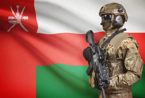 Soldat i hjälm holding kulspruta med flagga på bakgrunden-serien - Oman — Stockfoto