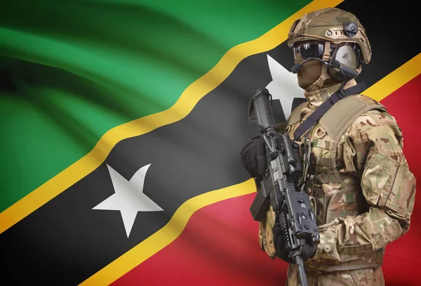 Voják v helmě drží kulomet s vlajkou na pozadí série - Svatý Kryštof a Nevis — Stock fotografie