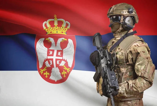 Soldado de capacete segurando uma metralhadora com bandeira na série de fundo - Sérvia — Fotografia de Stock
