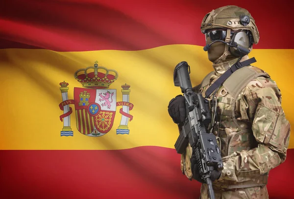 Soldier in helmet holding machine gun with flag on background series - Spain — Stock Photo, Image
