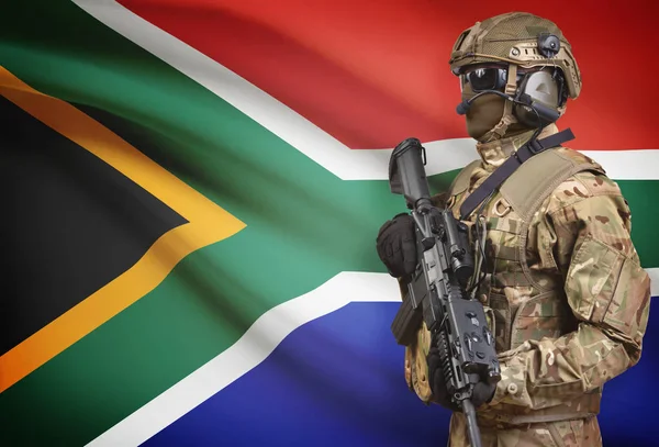 Soldier in helmet holding machine gun with flag on background series - South Africa — Stock Photo, Image