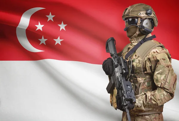 Soldier in helmet holding machine gun with flag on background series - Singapore — Stock Photo, Image
