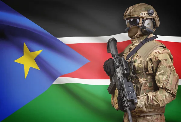 背景シリーズ - 南スーダンの旗と機関銃を保持しているヘルメットの兵士 — ストック写真