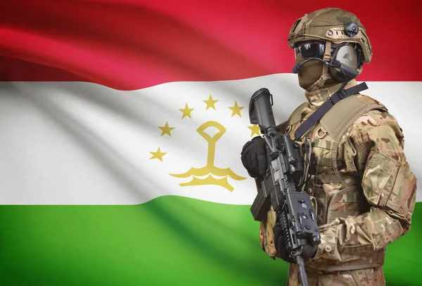 Soldato in casco detenzione machine gun con bandiera sulla serie della priorità bassa - Tagikistan — Foto Stock