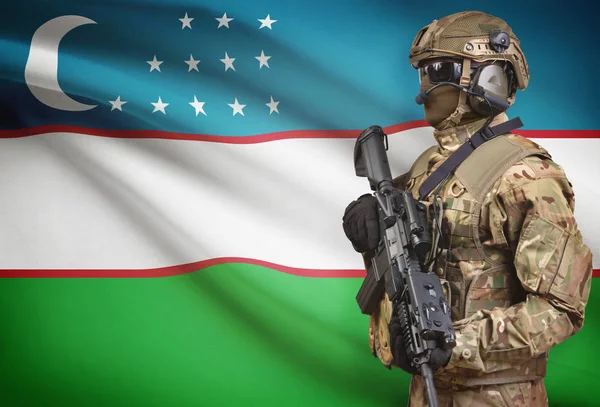 Soldaat in de helm bedrijf machinegeweer met vlag op de achtergrond serie - Oezbekistan — Stockfoto