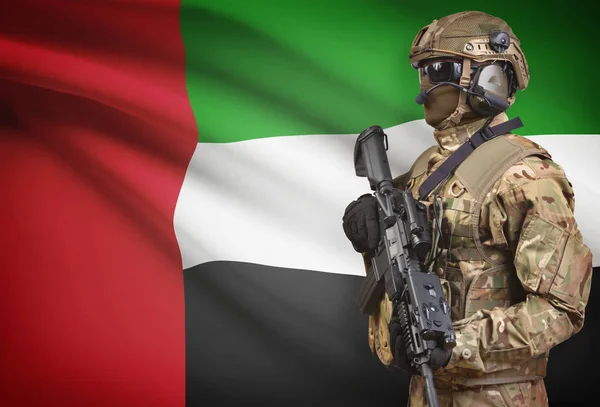 Soldato in casco detenzione machine gun con bandiera sulla serie della priorità bassa - Emirati Arabi Uniti — Foto Stock