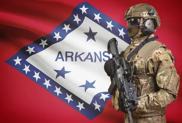 Soldier in helmet holding machine gun with USA state flag on background series - Arkansas — Stock Photo, Image