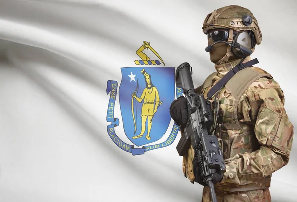 Soldat i hjälm holding kulspruta med Usa statsflagga på bakgrunden-serien - Massachusetts — Stockfoto