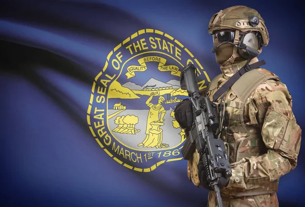 Soldier in helmet holding machine gun with USA state flag on background series - Nebraska — Stock Photo, Image