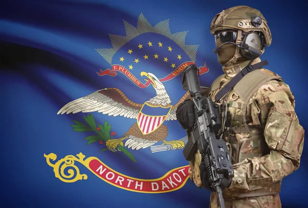Soldier in helmet holding machine gun with USA state flag on background series - North Dakota — Stock Photo, Image
