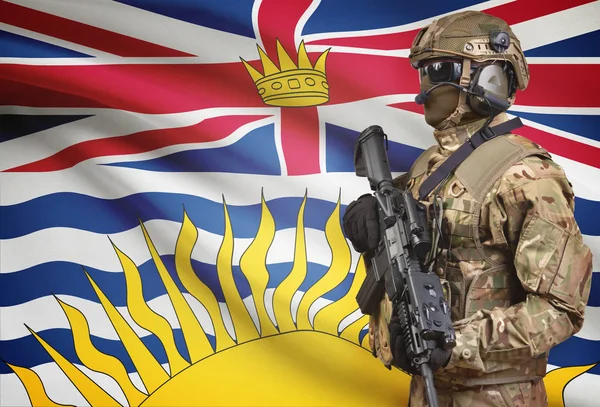 Soldier in helmet holding machine gun with Canadian province flag on background series - British Columbia — Stock Photo, Image