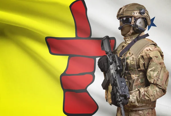 Солдат в шоломі, проведення кулемет з канадської провінції прапор на тлі серії - Нунавут — стокове фото