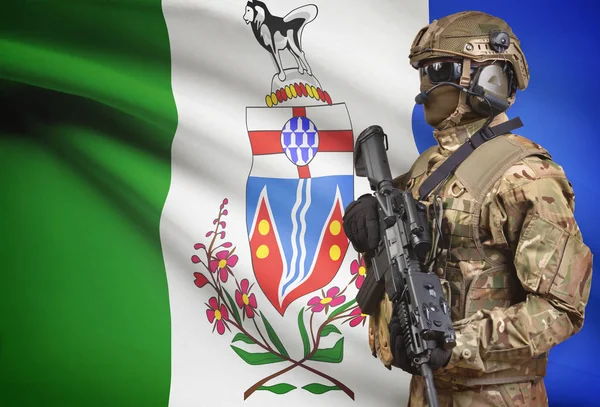 Soldado en casco con ametralladora con la bandera de la provincia canadiense en la serie de fondo - Yukon —  Fotos de Stock