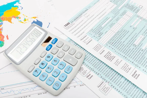 Nosotros formulario de impuestos 1040 con calculadora sobre él — Foto de Stock