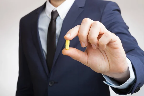 Businessman holding pill in hand — Stock Photo, Image