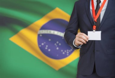 Arka plan - Brezilya Ulusal bayrakla bir ip üzerinde yaka kartı tutan işadamı