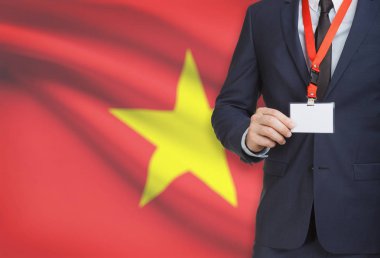 Arka plan - Vietnam üzerinde ulusal bayrakla bir ip üzerinde yaka kartı tutan işadamı