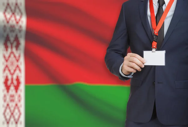 Geschäftsmann hält Namensschild Karte auf ein Schlüsselband mit einer Nationalflagge auf Hintergrund - Belarus — Stockfoto