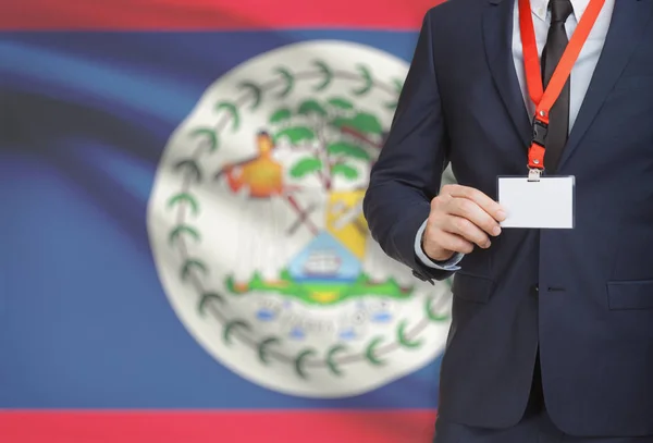 Homme d’affaires détenant des porte-nom carte sur une longe munie d’un drapeau national sur fond - Belize — Photo