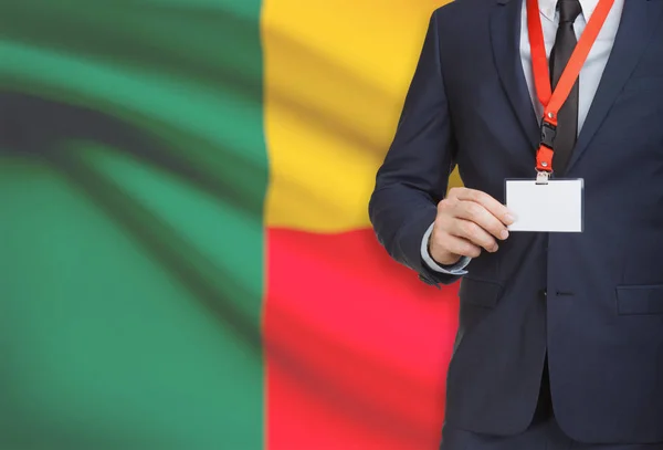 Biznesmen gospodarstwa karta identyfikator na smyczy z flagi narodowej na tle - Benin — Zdjęcie stockowe