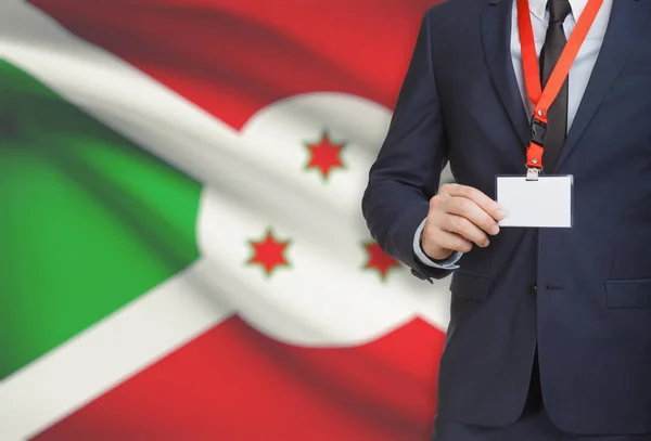 Biznesmen gospodarstwa karta identyfikator na smyczy z flagi narodowej na tle - Burundi — Zdjęcie stockowe