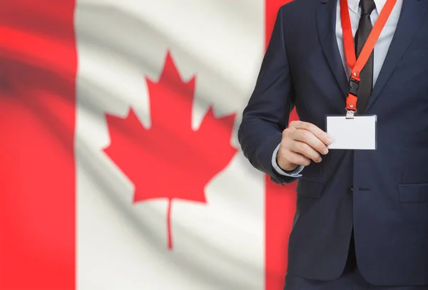 商人卡胸牌坚持挂绳与国旗上的背景-加拿大 — 图库照片