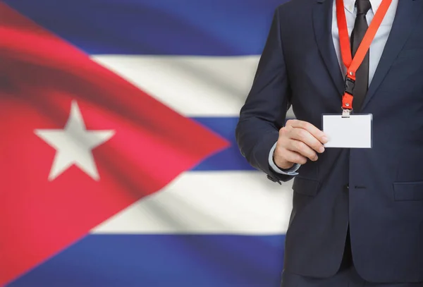 Zakenman kaart naambadge te houden op een lanyard met een nationale vlag op de achtergrond - Cuba — Stockfoto