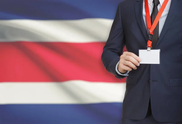 Empresário, segurando o distintivo de cartão nome em uma corda com uma bandeira nacional no plano de fundo - Costa Rica — Fotografia de Stock