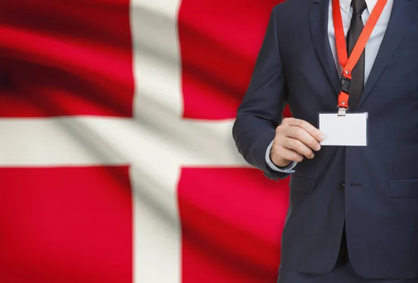 Businessman holding name card badge on a lanyard with a national flag on background - Denmark — Stock Photo, Image