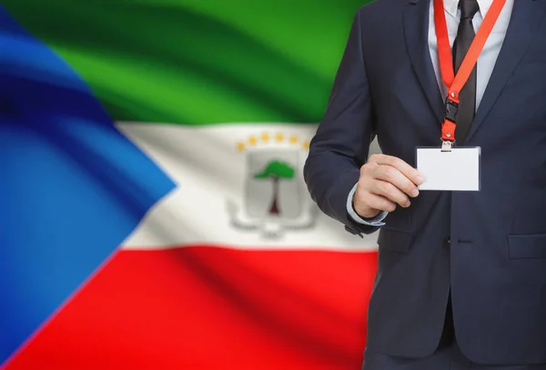 Homme d’affaires détenant des porte-nom carte sur une longe munie d’un drapeau national sur fond - Guinée équatoriale — Photo