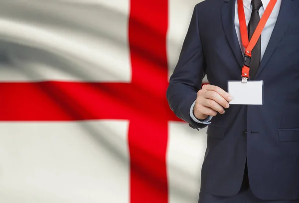 Businessman holding name card badge on a lanyard with a national flag on background - England — Stock Photo, Image