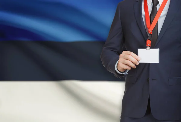 Businessman holding name card badge on a lanyard with a national flag on background - Estonia — Stock Photo, Image