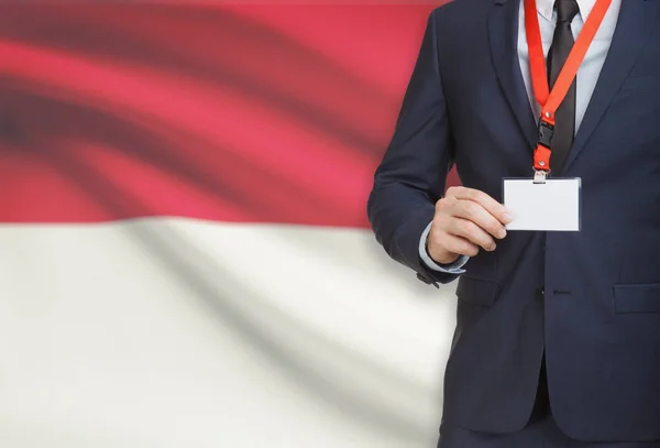 Businessman holding name card badge on a lanyard with a national flag on background - Indonesia — Stock Photo, Image