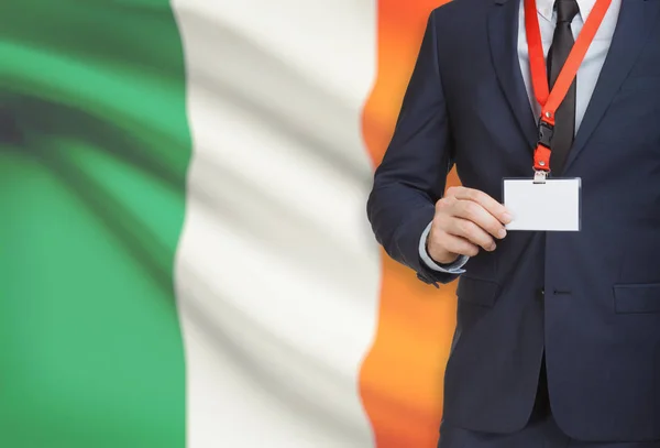 Businessman holding name card badge on a lanyard with a national flag on background - Ireland — Stock Photo, Image