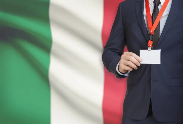 Homme d’affaires détenant des porte-nom carte sur une longe munie d’un drapeau national sur fond - Italie — Photo