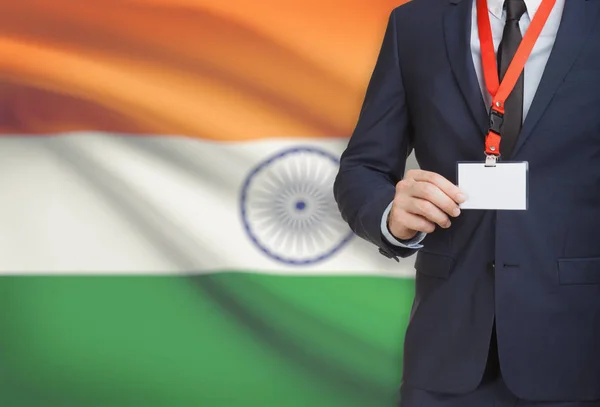 Бизнесмен, держа название карты badge на тросе с флагом на фоне - Индия — стоковое фото
