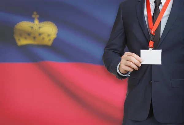 Zakenman kaart naambadge te houden op een lanyard met een nationale vlag op de achtergrond - Liechtenstein — Stockfoto