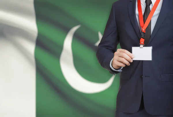 Empresario con credencial de la tarjeta en una cuerda con una bandera nacional de fondo - Pakistán — Foto de Stock