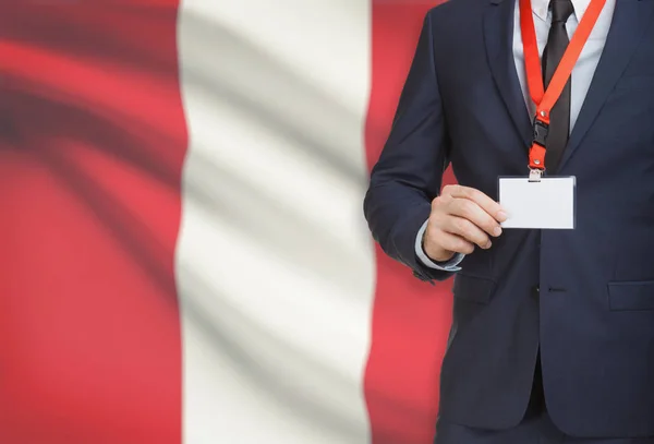 Businessman holding name card badge on a lanyard with a national flag on background - Peru — Stock Photo, Image