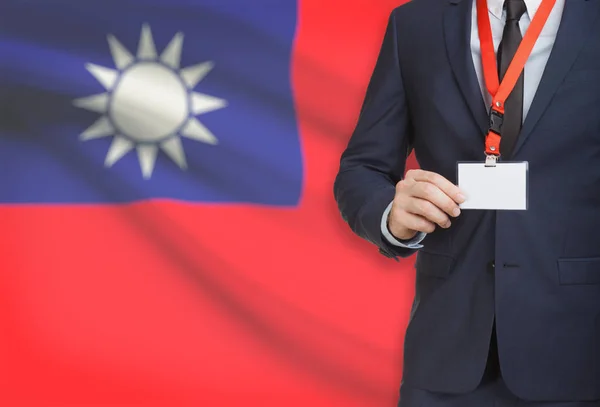 Uomo d'affari che tiene badge in carta su un cordino con una bandiera nazionale su sfondo - Taiwan - Cina — Foto Stock