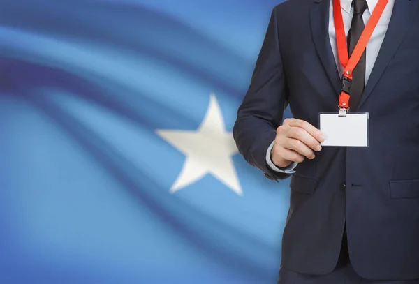 Businessman holding name card badge on a lanyard with a national flag on background - Somalia — Stock Photo, Image