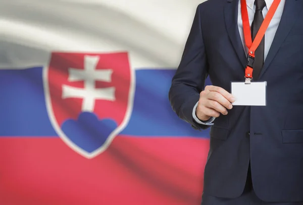 Geschäftsmann, ein Schlüsselband mit einer Nationalflagge auf Hintergrund - Slowakei Karte Namensschild festhalten — Stockfoto