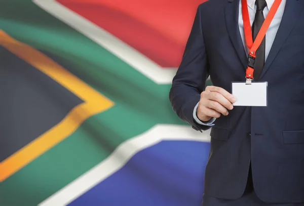 Businessman holding name card badge on a lanyard with a national flag on background - South Africa — Stock Photo, Image