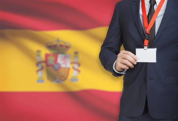 Geschäftsmann, ein Schlüsselband mit einer Nationalflagge auf Hintergrund - Spanien Karte Namensschild festhalten — Stockfoto